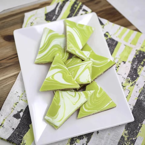 Une assiette blanche garnie de morceaux chocolatés verts et blancs.