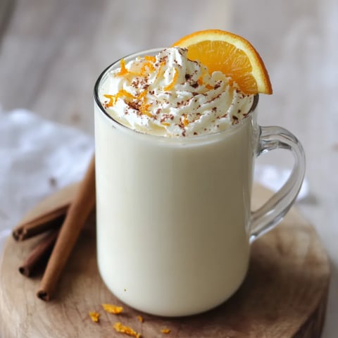 Un verre de lait coiffé d’une tranche d’orange.