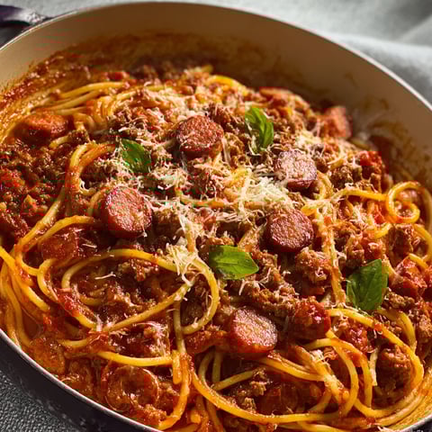 Une grosse marmite de spaghetti au bœuf haché et à la saucisse fumée.