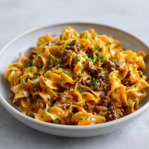 Sur une table, de généreuses nouilles garnies de boeuf, de sauce crémeuse et d’herbes fraîches.