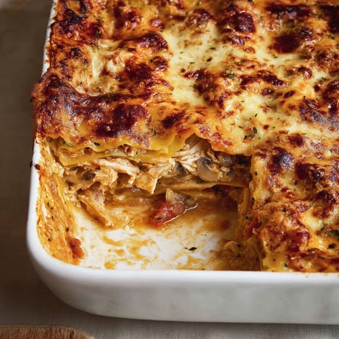 Une part de lasagne cacciatore dans un plat transparent.